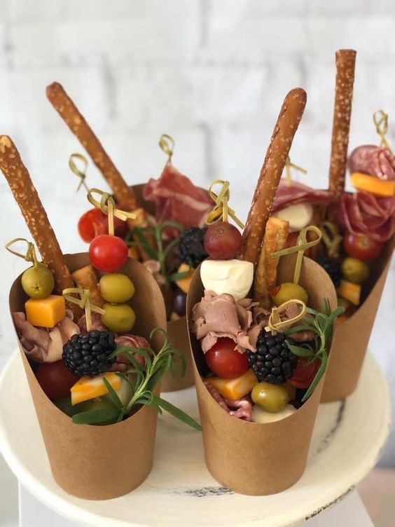 pretty and yummy looking charcuterie cups with olives and tomatoes, cheese and ham, herbs and salted cookies are gorgeous