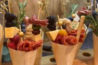 yummy-looking charcuterie cones with various types of cheese, salami, blackberries, herbs and berries are amazing for a summer wedding