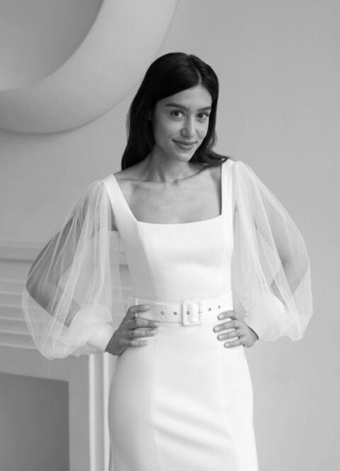 a lovely and chic modern plain wedding dress with a square neckline, sheer bell sleeves, a matching white belt