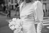 a beautiful mini dress with a high neckline and puff sleeves and a veil for an ultra-modern and very bold bridal look