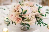 a blush wedding centerpiece of peonies, roses, peonies and greenery, candles around is a chic and tender idea for a spring or summer wedding