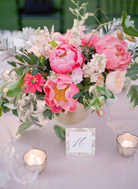 a bold wedding centerpiece of hot pink peonies, blush blooms, greenery and berries is a lovely idea for a pink summer wedding