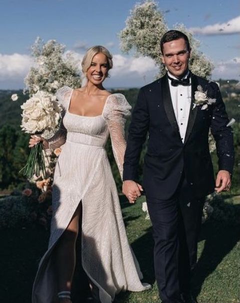 a chic modern A-line wedding dress, fully embellished, with a square neckline and puff sheer sleeves and a slit is amazing