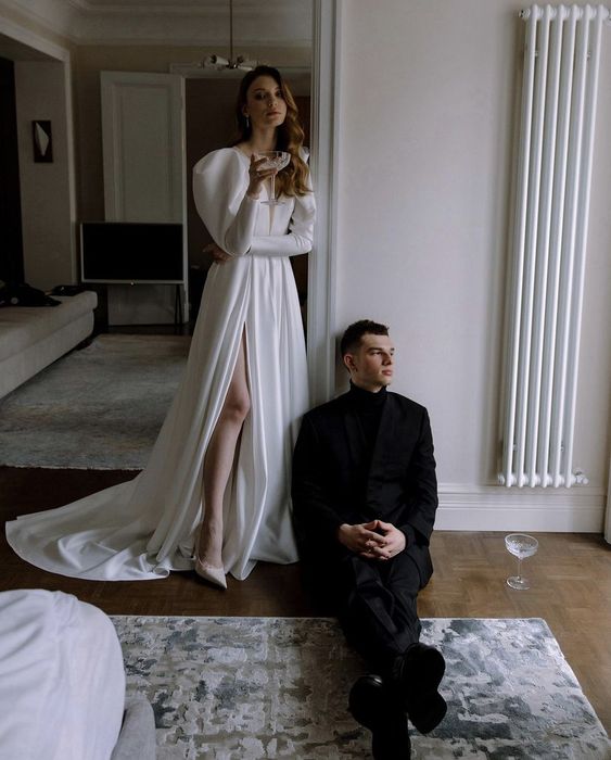 a chic modern plain wedding dress with puff sleeves, a plunging neckline, a thigh high slit and a train is a gorgeous idea for a Parisian wedding