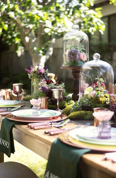 a fab enchanted forest wedding centerpiece of moss, greenery and dark and pink blooms and succulents is amazing and can be DIYed