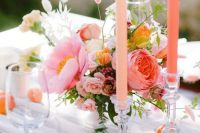 a gorgeous bright summer wedding centerpice of a pink peony, peony rose, small garden roses, bunny tails and a pink candle