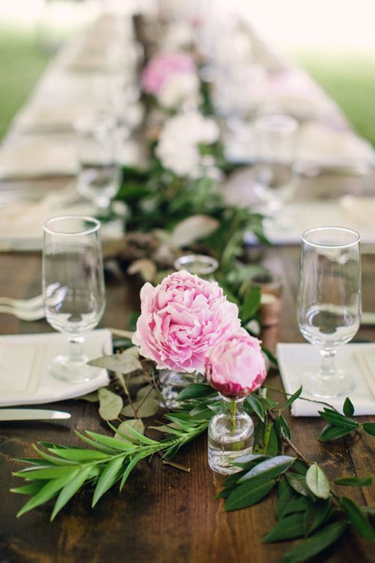 a greenery wedding table runner and pink peonies in clear vases is a bold and cool idea for a summer wedding