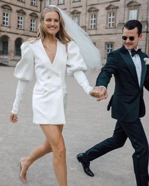 a puff sleeve blazer wedding dress, a veil and clear shoes compose an ultra-modern and bold bridal look