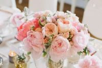 a refined and delicate summer wedding centerpiece of blush and pink peonies, peony roses and greenery for spring or summer