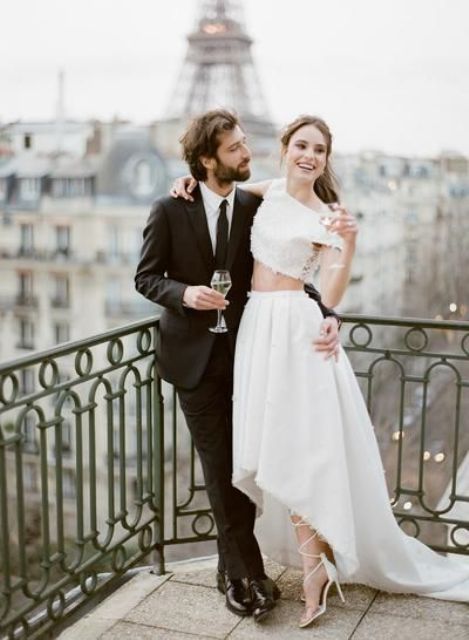 a refined modern Parisian bridal look with a lace off the shoulder crop top, a pleated high low midi skirt with a train