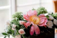 a rustic wedding centerpiece of greenery and pink blooms is a lovely idea for a rustic wedding in the summer