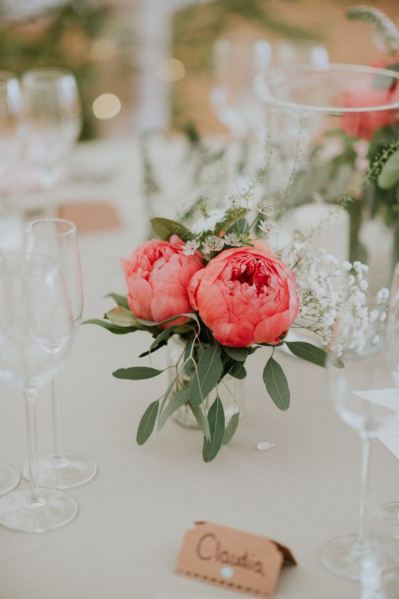a simple wedding centerpiece of bold pink peonies and white wildflwoers and greenery can be easily composed by you yourself