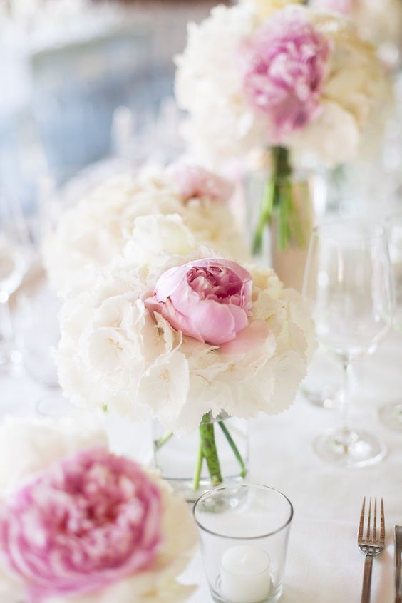 a tender and sweet wedding centerpiece of white blooms and a single pink peony is a lovely idea for spring or summer
