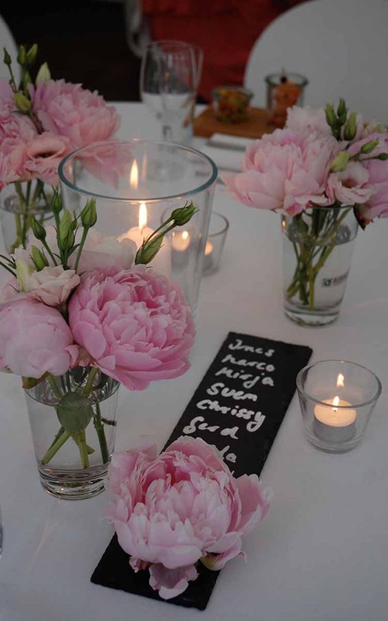 pink peonies in clear vases, pillar candles in clear candleholders and chalkboard menus for a chic and lovely summer wedding table