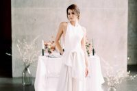 05 a chic minimalist bridal look with a sleeveless jumpsuit with a halter neckline, wideleg pants and a large bow on the waist