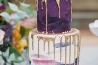 06 a catchy and chic wedding cake with a purple and a pastel brushstroke tier, with fresh berries, thistles and gold drip is a beautiful idea