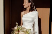 06 a lovely minimalist bridal look with a one shoulder mini dress with a long sleeve, a long veil and pearl hairpins plus a lovely bouquet