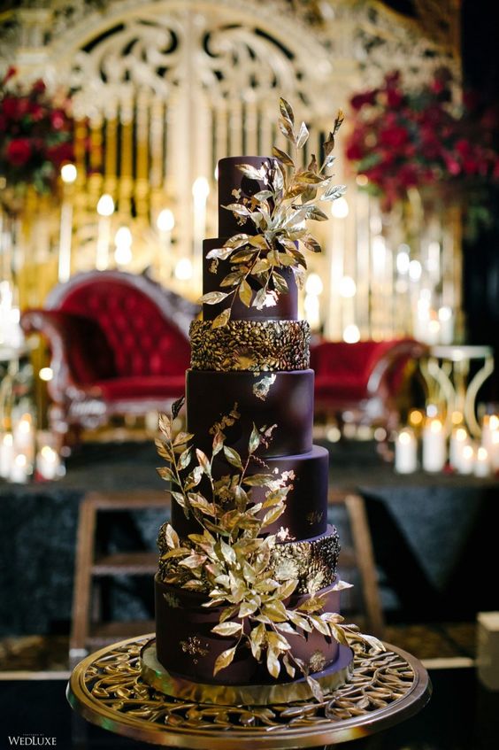 a deep purple wedding cake with gold blooms and gilded foliage is a fantastic idea for a fall wedding