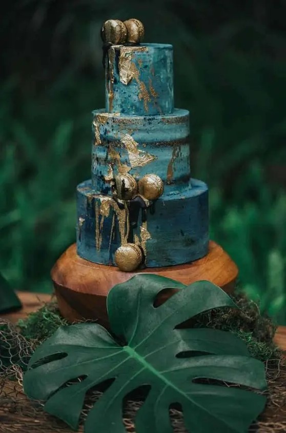 a beautiful blue textural wedding cake with an ombre effect, gold leaf and gold macarons is a stylish idea for a tropical wedding