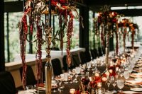 15 a Gothic meets rock tablescape with tall floral centerpiece and black candles, red petals and candles on the table, red napkins