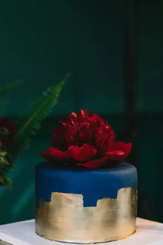 a navy wedding cake with gold foil and a large burgundy bloom on top is a fantastic idea for a bold fall wedding