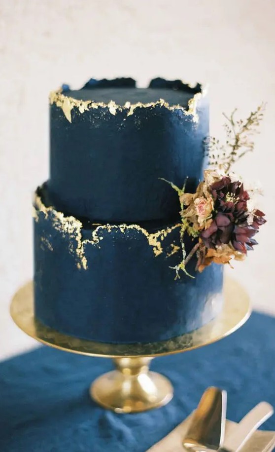 a refined and chic bold navy cake with a rough golm rim, with dark blooms and leaves is a very exquisite idea to go for