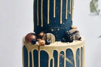 21 an edgy navy wedding cake with gold drip and gold glitter, with gilded berries, sugar and chocolate marble touches and black shards on top