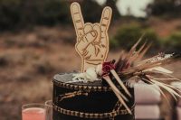 23 a black rock-inspired spiked wedding cake with grasses and blooms and a fun cake topper is a great idea for a rock wedding