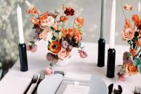 23 a bold minimalist wedding tablescape with neutral linens, a grey plate, black candleholders and neutral candles and bright blooms
