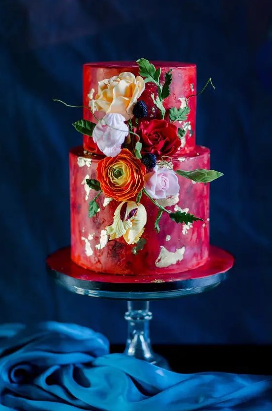 a bright red watercolor wedding cake with gold leaf, orange, pink and red blooms, leaves and berries is a gorgeous idea for a bold and colorful wedding