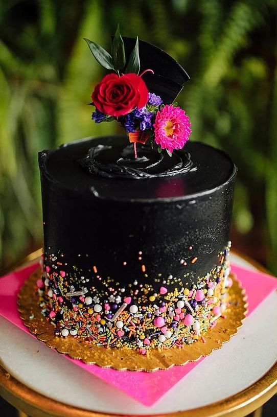 a colorful rock wedding cake with bright confetti, bright blooms and greenery on top is a great idea for a rock n roll wedding