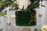 28 a bold emerald and white wedding cake with a pleated tier and a sleek one with gold leaf and a hoop with greenery for a modern wedding