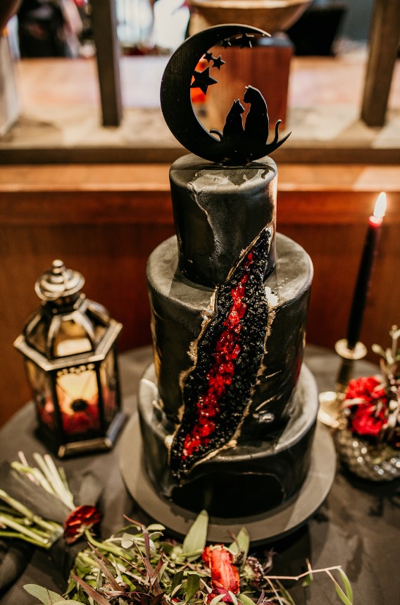 a fantastic black wedding cake with geode detailing, a celestial cat cake topper is amazing for a rock n roll wedding