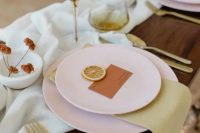 32 a minimalist fall wedding tablescape with matte pink plates and chargers, gold cutlery and colored glasses, a bit of dried blooms