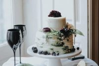 34 a textural wedding cake topped with leaves, berries and dark purple blooms looks appropriate for a rock n roll wedding
