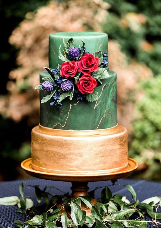 a statement green marble and gold wedding cake with fresh and sugar blooms of jewel tones and foliage