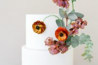 42 a beautiful wedding cake in white decorated with bodl orange and mauve blooms and greenery is a lovely idea for a modern or minimal fall wedding