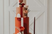 47 a bold orange, rust, blush wedding cake with bold blooms, feathers and grasses and bright sugar detailing for a 70s wedding
