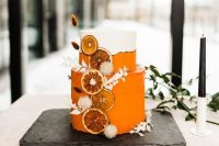 50 a stunning white and orange wedding cake with white dried grasses and dried citrus slices is a lovely idea for a tropical boho wedding
