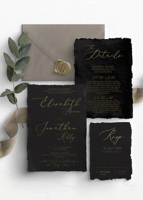 a bold wedding invitation suite of handmade paper, with black invites and a grey envelope, with gold calligraphy and a seal