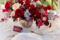 a bright jewel tone wedding centerpiece of deep red, burgundy, lilac, pink and peachy blooms is a gorgeous and sumptuous idea for the fall