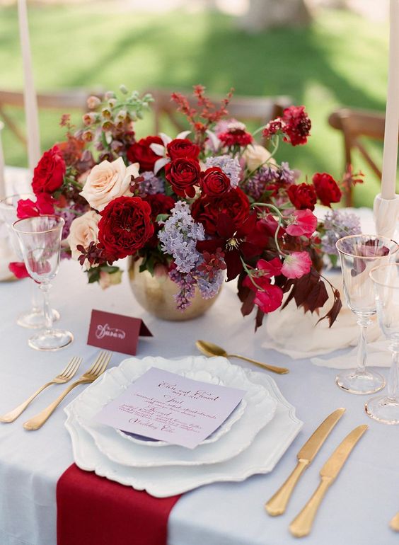 a bright jewel tone wedding centerpiece of deep red, burgundy, lilac, pink and peachy blooms is a gorgeous and sumptuous idea for the fall