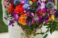 a chic and bold wedding bouquet with red, orange, violet and fuchsia blooms and plus some cascading touches