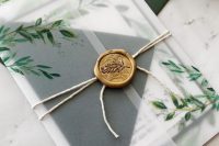 a chic botanical wedding invitation suite with a vellum botanical jacket, a traditional envelope inside and a chic gold seal