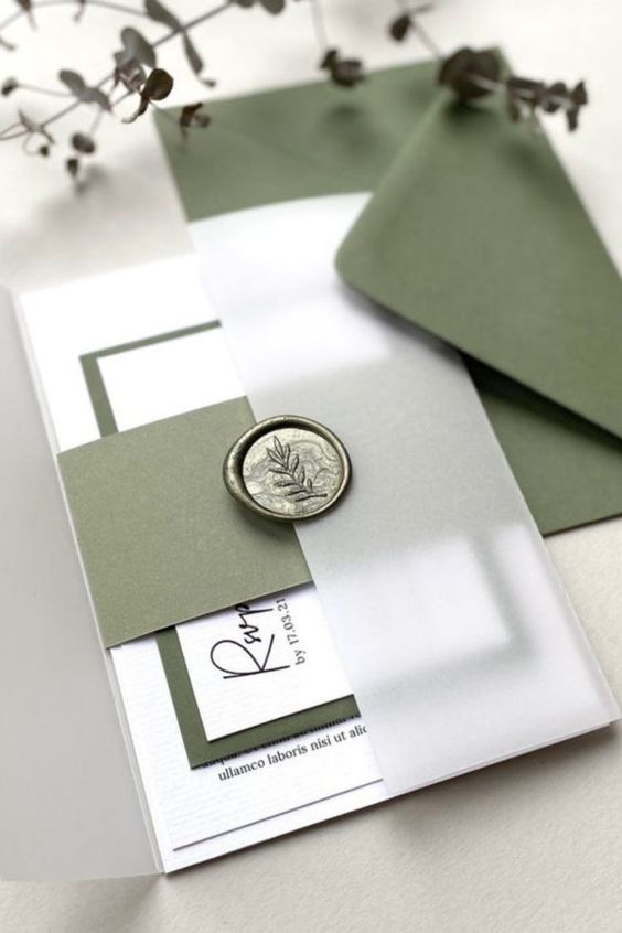 a classy green and white wedding invitation suite with a green envelope, green and white invites, a green botanical seal
