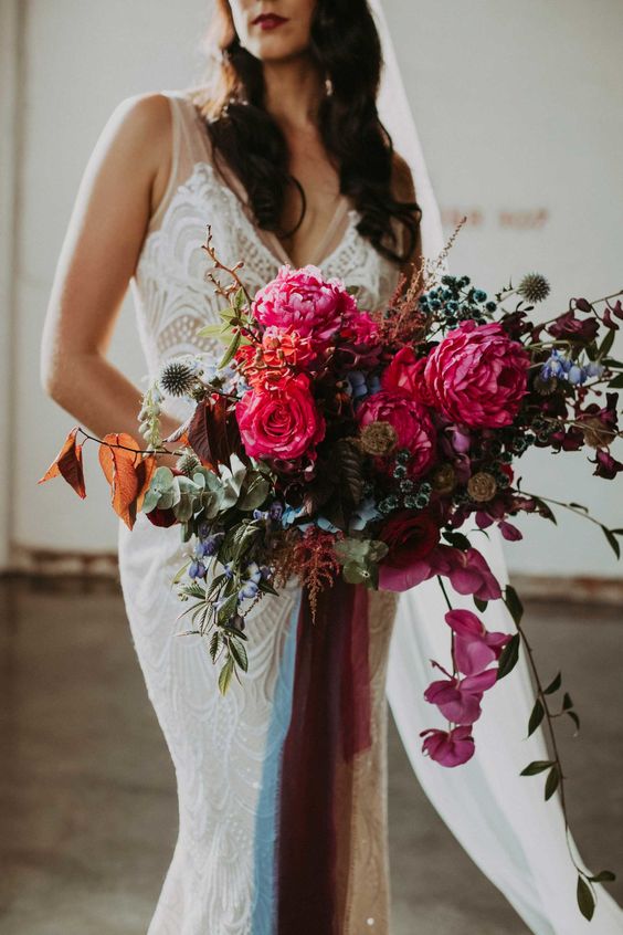a cool wedding bouquet of pink, red, purple and blue blooms, greenery and some long ribbon is a great idea for the fall