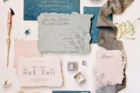 a fab wedding invitation suite with handmade paper envelopes and invitations in blue, blush and light green, with calligraphy