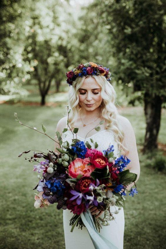 a fabulous jewel tone wedding bouquet of violet, burgundy, pink, bold blue blooms and greenery and seed pods is amazing