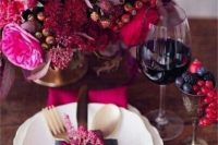 a jaw-dropping sumptuous wedding centerpiece with hot red, hot pink, purple blooms, various berries and no foliage is wow