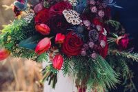 a jaw-dropping wedding bouquet of burgundy, red, pirple blooms, greenery and blue thistles plus much texture is wow